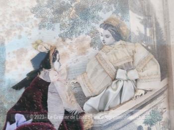 Vraiment vintage et rétro, voici un cadre vitrine de 27 x 34.5 cm et 5 cm de profondeur mettant en valeur une gravure de "Les Modes Parisiennes" avec en relief robes, bustier et chapeaux en tissus. Superbe !