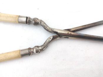 Voici un ancien petit fer à friser en métal  avec les deux manches en métal ouvragé et habillé de bakélite couleur ivoire, un en forme de cylindre et l'autre en gouttière, pour bonne une prise en main et de belles boucles.