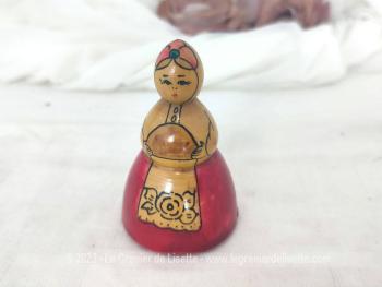 Voici une ancienne petite poupée russe en bois de forme conique représentant une boulangère avec encore son étiquette en écriture cyrillique dessous.