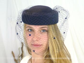 En feutre marine, voici un beau chapeau forme tambourin avec une forme en v sur le devant et sa voilette marine à pois et son élastique pour maintenir dans les cheveux .
