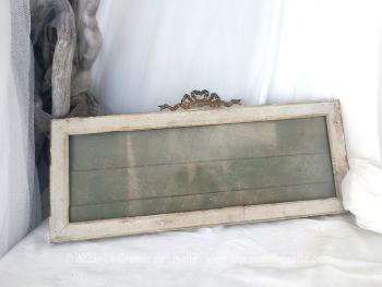 Voici un ancien cadre rectangulaire de 18 x 45 cm avec un fond  en papier tapisserie et surmonté d'un noeud doré, datant de la fin XIX° ou début XX°. A poser ou à suspendre.