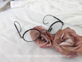 Avec des verres loupes, voici une ancienne paire de lunettes rondes au contour en bakélite imitation écaille de tortue avec des branches qui se terminent par un système à spirale flexible.