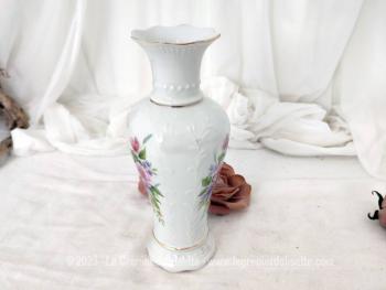 Voici un adorable petit vase des années 70 formé par 3 pans arrondis et décoré sur ses 3 faces par un bouquet de fleurs aux tons pastel. Il porte l'estampille 