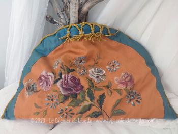 Voici un ancien coussin en forme de demi-lune de 50 cm de large à la base et 30 cm au plus haut avec peint à la main, un superbe décor floral peint sur un tissus satine orangé.