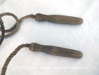 Voici une ancienne corde à sauter avec corde et manche en bois .