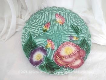 Datant des années 80, voici une grande assiette plate ou plat de service en barbotine décorée dans des tons pastel de fleurs et d'un papillon, très tendance shabby et estampillée de la marque Geneviève Lethu .