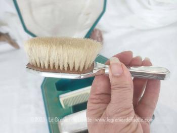 Voici un ancien coffret contenant un nécessaire de toilette en métal argenté comprenant une brosse à habits, un peigne, un pot à onguent, et une brosse à cheveux.