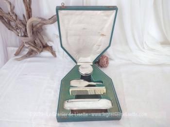 Voici un ancien coffret contenant un nécessaire de toilette en métal argenté comprenant une brosse à habits, un peigne, un pot à onguent, et une brosse à cheveux.b