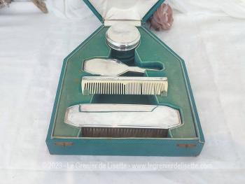 Voici un ancien coffret contenant un nécessaire de toilette en métal argenté comprenant une brosse à habits, un peigne, un pot à onguent, et une brosse à cheveux.