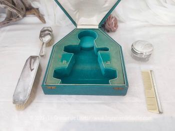 Voici un ancien coffret contenant un nécessaire de toilette en métal argenté comprenant une brosse à habits, un peigne, un pot à onguent, et une brosse à cheveux.