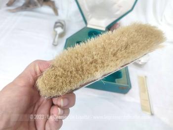 Voici un ancien coffret contenant un nécessaire de toilette en métal argenté comprenant une brosse à habits, un peigne, un pot à onguent, et une brosse à cheveux.