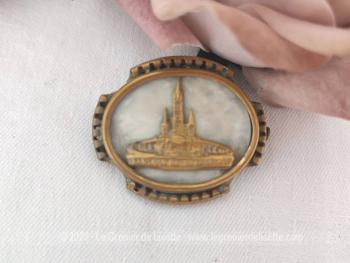 Voici une belle broche vintage en laiton aux contours ciselés avec pour décors sur un fond nacré en bakélite la Basilique ND de Lourdes en laiton.