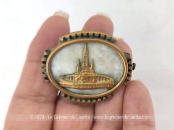Voici une belle broche vintage en laiton aux contours ciselés avec pour décors sur un fond nacré en bakélite la Basilique ND de Lourdes en laiton.
