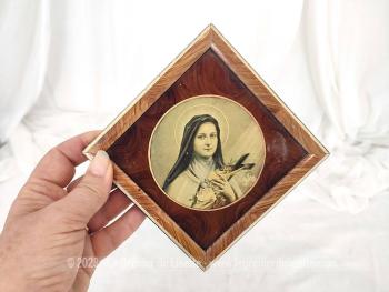 Petit cadre reliquaire en forme de losange représentant Sainte Thérèse de Lisieux composé d'une vitre en verre et d'un contour en bois placage loupe d'orme.