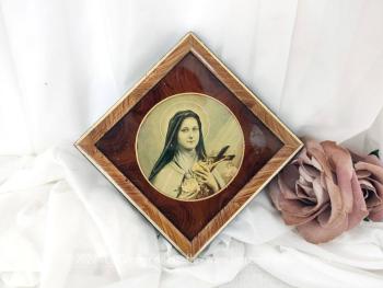 Petit cadre reliquaire en forme de losange représentant Sainte Thérèse de Lisieux composé d'une vitre en verre et d'un contour en bois placage loupe d'orme.