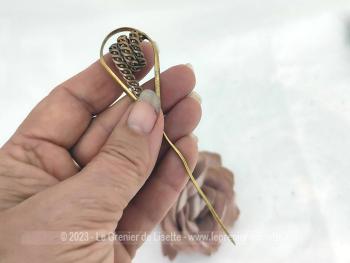 Sur 10.5 cm de long,  voici une ancienne épingle à chapeaux en laiton avec un décor en forme de spirale ciselée inséré dans une arche fine pour la mettre en valeur comme un bijoux.