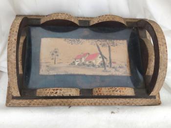 Datant des années 50/60 et fait main, voici un ancien petit plateau en bois mettant en valeur un paysage réalisé en pyrogravure et signé, surmonté d'une vitre. Pièce unique.