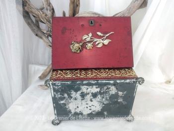 Ancienne belle boite métallique sérigraphié en rouge et or  avec sur le couvercle une fleur dorée en relief. Il y a 4 pieds ouvragés et une serrure et une clé.