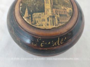 Sur 4.5 x 8,2 cm, voici une belle boite en bois tourné, petit vide poche ou bonbonnière, portant sur le couvercle la photo de la Basilique de Lourdes et sur le coté l'inscription 