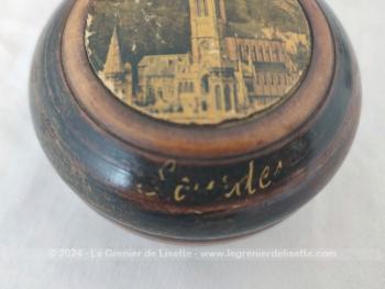 Sur 4.5 x 8,2 cm, voici une belle boite en bois tourné, petit vide poche ou bonbonnière, portant sur le couvercle la photo de la Basilique de Lourdes et sur le coté l'inscription "Lourdes".