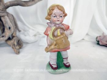 Voici un adorable couple de statuettes vintages en porcelaine biscuit avec de beaux visages tout ronds, au traits peints à la main avec une petite fille avec un arrosoir et un petit garçon avec une pelle.