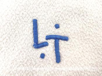 Duo d'adorables serviettes de 58x 90 cm en éponge blanches brodées des monogrammes LT en bleu.