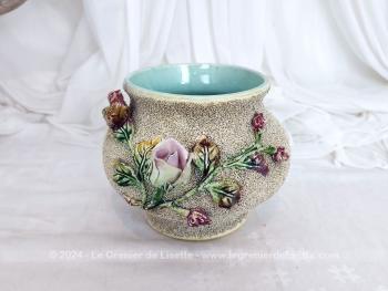 Datant des années 50/60, voici un beau et cache pot ou vase en céramique avec habillage vermiculé et barbotine avec un beau décor floral dans les tons de rose et mauve. Numéroté mais sans estampillé de manufacture.