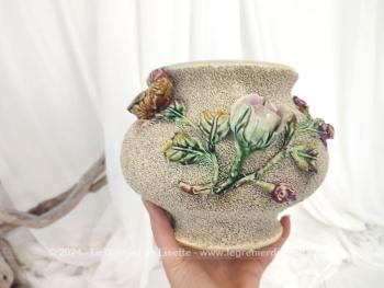 Datant des années 50/60, voici un beau et cache pot ou vase en céramique avec habillage vermiculé et barbotine avec un beau décor floral dans les tons de rose et mauve. Numéroté mais sans estampillé de manufacture.