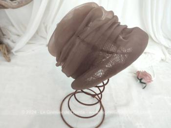 Voici un ancien chapeau en forme de toque composé par un entassement de différents plis de voile synthétique couleur chocolat au lait, pour former des étages. Fait main et facile à relooker si vous le souhaitez !