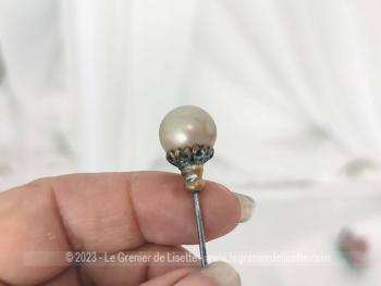 Sur 18.5 cm de long, voici une ancienne épingle à chapeau composée d'une grande perle nacrée sertie dans un superbe travail ouvragé et ciselé en laiton. Idéale pour chapeaux ou en décoration.