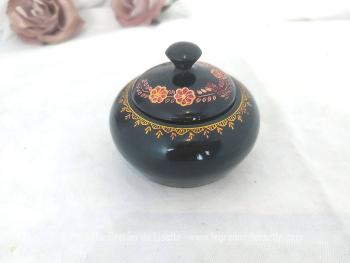 Sur 8 x 8,5 cm, voici une belle boite en bois tourné, petit vide poche ou bonbonnière, laquée en noir et décorée d'une guirlande de fleurs dans les tons orangés.