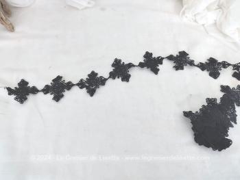 Un beau coupon de 180 x 6 cm de dentelle noire, composée d'une succession de formes géométriques identiques reliées les unes aux autres pour former une guirlande.