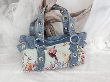 Un véritable sac Cacharel  avec son label et ses breloques, datant des années 90, vraiment original avec ses lanières en jean perforées et décoré d'un tissus floral.