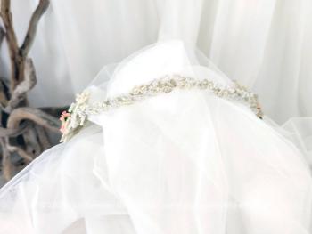 Vintage, voici une couronne de mariée composée d'une guirlande de perles nacrées avec décors de chaque coté d'un bouquet de fleurs en dentelle avec au centre une fleur en tissus rose saumon. 