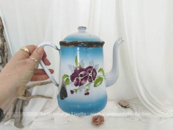 Voici une ancienne cafetière habillé d'un fond bleu ciel et blanc en émail et décorée de grosses pensées violettes sans oublier son couvercle et tout le charme de l'authentique avec ses éclats.