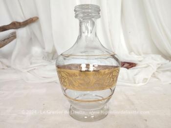 Voici une superbe carafe vintage ornée d'une belle guirlande de décorations dorées et son bouchon .