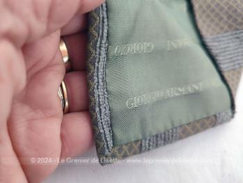 Voici une superbe cravate vintage seventeen de la marque Giorgio Armani décorée de motifs décoré gris et taupe avec renfort satiné au cou et doublure estampille Giorgio Armani.