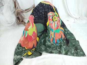 En soie naturelle, voici un foulard de 88 x 85 cm entièrement peint à la main avec un fond en dégradé de verts par des effets de peintures et des dessins de grandes fleurs  multicolores.
