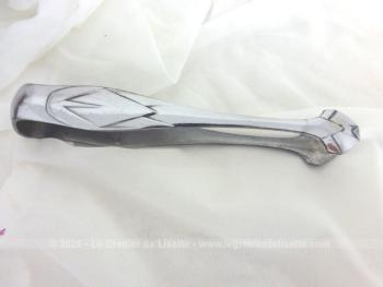 Ancienne pince à sucre en inox à la forme et aux décors dans le style Art Nouveau avec pinces triangulaires.