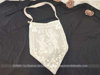 Fait main, voici une pochette ou sac à porter à l'épaule ou à suspendre, se terminant en pointe et décoré sur une face de la dentelle avec un dessin d'angelots et au dos du coton de lin écru. Intérieur doublé de satin. Pièce unique.