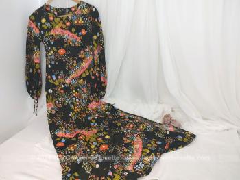 Taille 40 et de la marque Gemma, voici une belle robe longue aux manches longues et fendue sur le coté réalisée dans un tissus polyester, légèrement extensible,  dans une coupe vraiment dans les style des années 70.