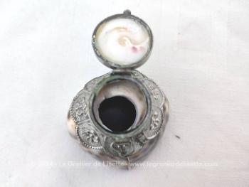 Adorable petite boite à tabac, à chapelet composée d'un socle réalisé à partir d'un coquillage décoré de métal ouvragé et habillé d'un couvercle en coquillage aussi et surmonté d'un décor métallique. Socle en résine.