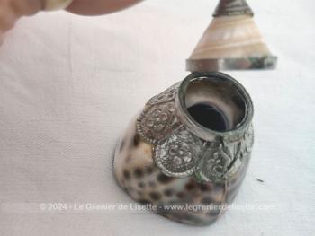 Adorable petite boite à tabac, à chapelet composée d'un socle réalisé à partir d'un coquillage décoré de métal ouvragé et habillé d'un couvercle en coquillage aussi et surmonté d'un décor métallique. Socle en résine.