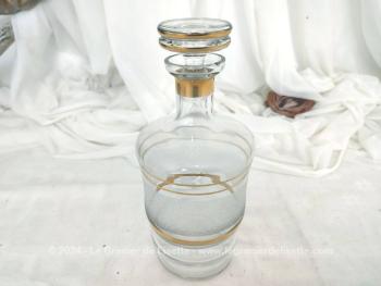 Voici une élégante carafe vintage ornée de liserés dorées et d'une bande de verre granité blanc sans oublier son superbe bouchon .