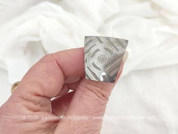 Sur 4.5 cm de long, voici une ancienne épingle à chapeaux courte avec en décoration une forme géométrique ouvragée en métal argenté dans un style Art Déco.