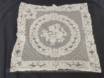 Voici un superbe et ancien napperon presque de forme carrée en tulle avec des incrustations de dentelle et un motif floral au centre.
