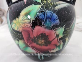 Datant des années 60, voici un superbe vase à double anses sur fond noir avec des dessins de fleurs colorées, provenant des faïences Monacera de Monaco. Vintage !