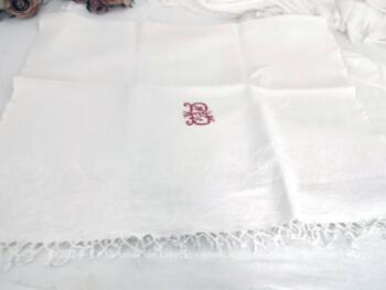 Voici une ancienne serviette blanche de 60 x 100 cm en damassé blanc avec franges à noeud et brodée du monogramme B au point de croix en fils rouges. Top vintage et shabby !