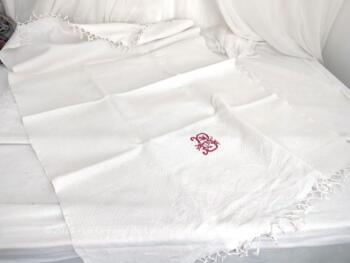 Voici une ancienne serviette blanche de 60 x 100 cm en damassé blanc avec franges à noeud et brodée du monogramme B au point de croix en fils rouges. Top vintage et shabby !