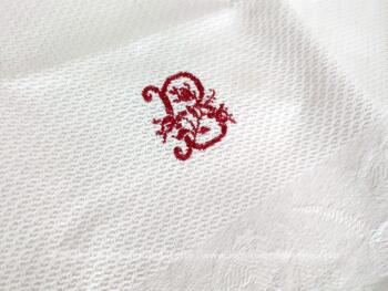Voici une ancienne serviette blanche de 60 x 100 cm en damassé blanc avec franges à noeud et brodée du monogramme B au point de croix en fils rouges. Top vintage et shabby !